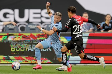 New York City FC defender Mitja Ilenic fights for the ball against Atlas' Jorge Guzman.